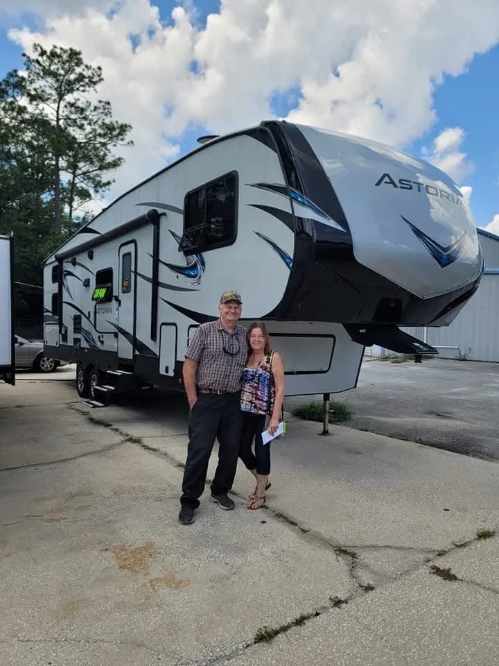 Couple in front of their Grand Design Astoria fifth wheel