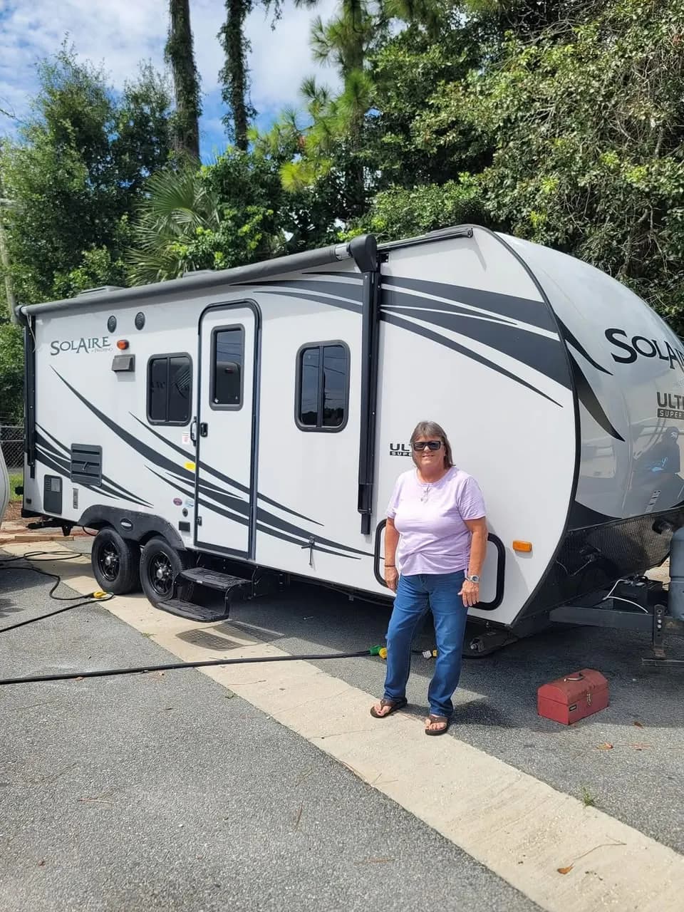 Customer beside her Palomino Solaire Super Lite travel trailer