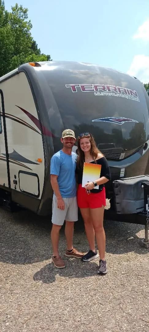Young couple in front of their Terrain Ultralite travel trailer
