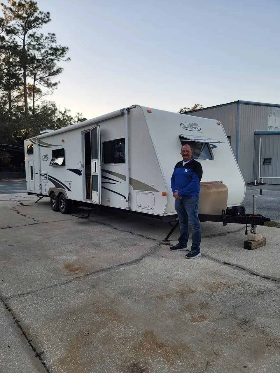 Customer in front of his Trail Cruiser travel trailer at sunset